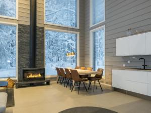 a dining room with a table and chairs and a fireplace at Holiday Home Levin hiihtäjä by Interhome in Sirkka