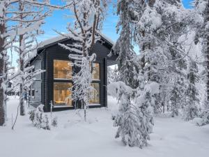 a cabin in the woods with snow covered trees at Holiday Home Levin hiihtäjä by Interhome in Sirkka