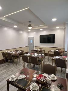 a dining room with tables and chairs and a flat screen tv at Tudor Rose Hotel in Blackpool