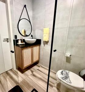 a bathroom with a sink and a mirror at La vita hospedaria (quarto amarelo) in Nova Veneza