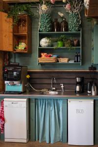 - une cuisine avec un évier et des étagères avec des légumes dans l'établissement Bloem & Bed, à Stolpen