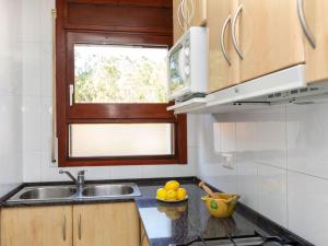 eine Küche mit Spüle und eine Schale mit Obst auf der Theke in der Unterkunft Apartment Maridor-2 by Interhome in Platja  d'Aro