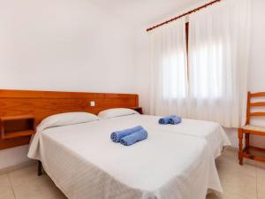 ein Schlafzimmer mit zwei blauen Handtüchern auf einem Bett in der Unterkunft Apartment Maridor-2 by Interhome in Platja  d'Aro