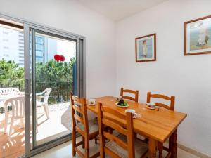 ein Esszimmer mit einem Holztisch und Stühlen in der Unterkunft Apartment Maridor-2 by Interhome in Platja  d'Aro