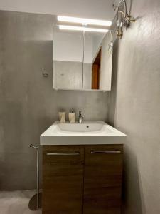 La salle de bains est pourvue d'un lavabo blanc et d'un miroir. dans l'établissement Bitter Orange House, à Nerántza