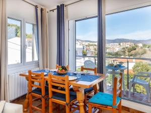 Un comedor con mesa y sillas y una gran ventana. en Apartment Faner by Interhome, en Llançà