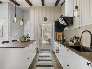 una cocina con armarios blancos y fregadero en Holiday Home Sighfrith - all inclusive - 2km from the sea by Interhome, en Blokhus