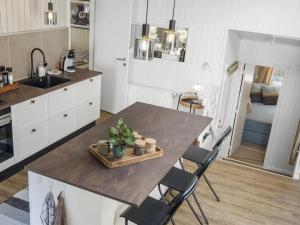 cocina con mesa con sillas y fregadero en Holiday Home Sighfrith - all inclusive - 2km from the sea by Interhome, en Blokhus