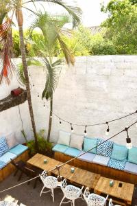 un patio con sofá, mesa y palmeras en Casa Coco Hostel, en Santa Ana