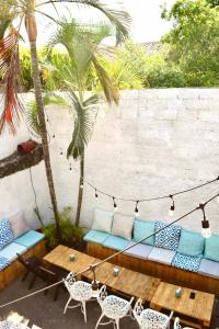a patio with a couch and a table and palm trees at Casa Coco Hostel in Santa Ana