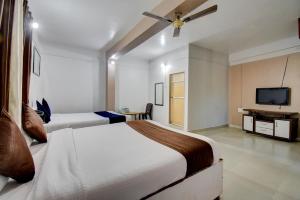 a bedroom with two beds and a flat screen tv at The Greenpark Retreat, Mahabaleshwar in Mahabaleshwar