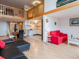 a living room with a red couch and a table at Apartment Les Lofts-17 by Interhome in Dives-sur-Mer