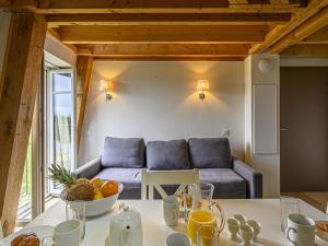 a living room with a couch and a table with a bowl of fruit at Apartment Le Château de Kergonano-20 by Interhome in Baden