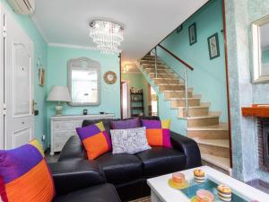a living room with a black leather couch and stairs at Holiday Home Villa Angeles by Interhome in L'Ametlla de Mar