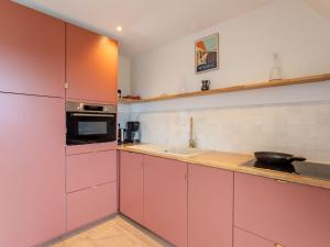 ドーヴィルにあるApartment Le Carrousel des Sports by Interhomeのピンクのキャビネットとシンク付きのキッチンが備わります。