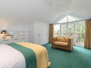 - une chambre avec un lit, une chaise et une fenêtre dans l'établissement The Gardener's Bothy, à Penrith
