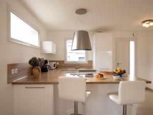 uma cozinha com duas cadeiras brancas e uma bancada em Holiday Home Chez Jeff by Interhome em Ploudalmézeau