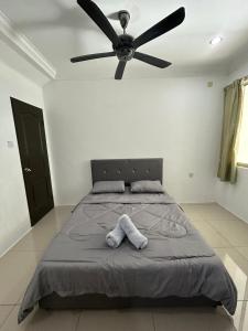 1 dormitorio con 1 cama y ventilador de techo en H&N Airbnb, en Miri