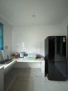 uma cozinha com um frigorífico e uma bancada em H&N Airbnb em Miri