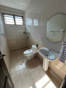 y baño con aseo y lavamanos. en H&N Airbnb, en Miri