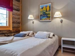 two beds in a room with two lamps on the wall at Holiday Home Nilikuru g18 by Interhome in Saariselka