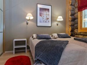 two beds in a room with two lamps on the wall at Holiday Home Nilikuru g18 by Interhome in Saariselka
