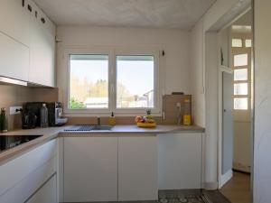 une cuisine avec des placards blancs et une fenêtre dans l'établissement Holiday Home Chez Eric by Interhome, à Névez