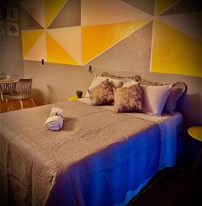 a bedroom with a bed with a colorful wall at La vita hospedaria (quarto amarelo) in Nova Veneza