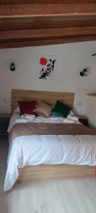 1 dormitorio con 1 cama grande y cabecero de madera en Xenia Alojamientos, en Santiago de la Espada