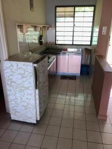 a kitchen with a refrigerator and a tile floor at PD Infront Seaview in Port Dickson