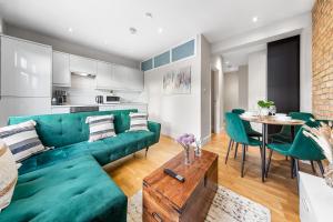 a living room with a green couch and a table at Boho 1-BR Peakham Rye Lane in London