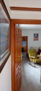 a door to a living room with a green couch at Xenia Alojamientos in Santiago de la Espada