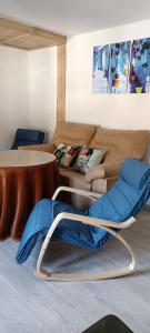 sala de estar con sofá y silla en Xenia Alojamientos, en Santiago de la Espada