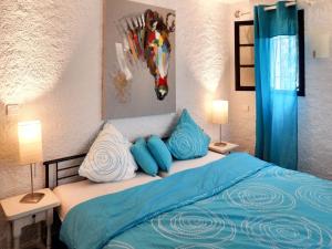 ポルト・ヴェッキオにあるVilla de 4 chambres a Porto Vecchio a 160 m de la plage avec jardin clos et wifiのベッドルーム1室(青と白の枕が備わるベッド1台付)