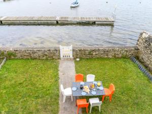 un tavolo e delle sedie seduti sull'erba vicino all'acqua di Holiday Home Maison du Port by Interhome a Locmariaquer