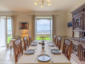una sala da pranzo con tavolo, sedie e una finestra di Holiday Home Maison du Port by Interhome a Locmariaquer Altre 15 foto