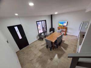 a dining room with a table and chairs and a tv at Punto Mar in Balneario Claromecó