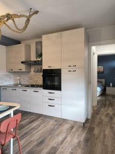 eine Küche mit weißen Schränken, einem Tisch und einem Esszimmer in der Unterkunft Appartamento - Centro Storico in Savigliano