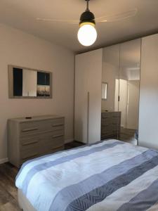 ein Schlafzimmer mit einem großen Bett und einer Kommode in der Unterkunft Appartamento - Centro Storico in Savigliano