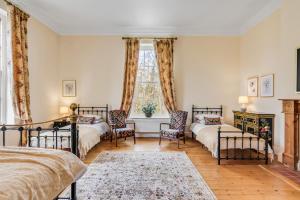 a bedroom with two beds and a window at Stunning Historic Suffolk Mansion in Beccles