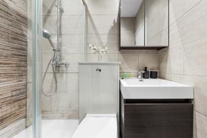 uma casa de banho com um lavatório branco e um chuveiro em Boho 1-BR Peakham Rye Lane em Londres