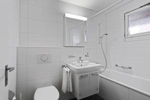 a bathroom with a sink and a toilet and a tub at Fantastic 2 bedroom flat close to the lake (Mainau 4) in Zürich