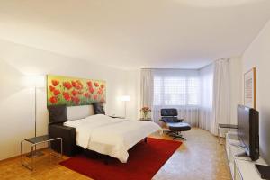 a bedroom with a bed and a flat screen tv at Fantastic 2 bedroom flat close to the lake (Mainau 4) in Zürich