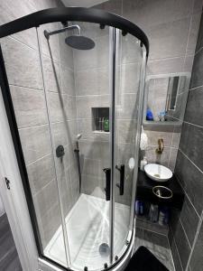 a shower with a glass door in a bathroom at Tranquil Oasis in Gravesend - Private Rooms in Northfleet