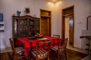 a dining room with a table with chairs and a bowl of fruit at Simaza Villa in Kigali
