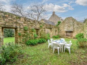 a table and chairs in front of a stone building at Holiday Home Maison Maison Ty Mad by Interhome in Belz