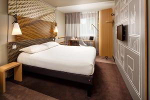 a hotel room with a bed and a tv at ibis London Stratford in London