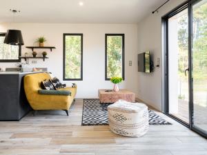 a living room with a yellow chair and a table at Holiday Home Hotel du Nord by Interhome in Mimizan