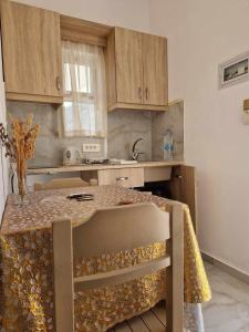 a kitchen with a table with a chair in it at Christina Studios in Kefalos