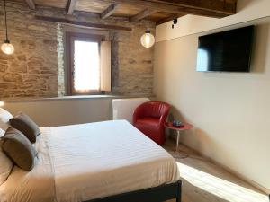 een slaapkamer met een bed en een rode stoel bij Ca' Nobili - Charming Country House 